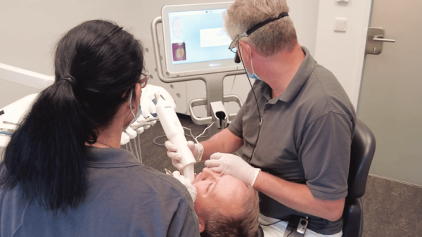 Dr Herzberg scans the denture of the patient with an intraoral scanner and a display shows it in real time