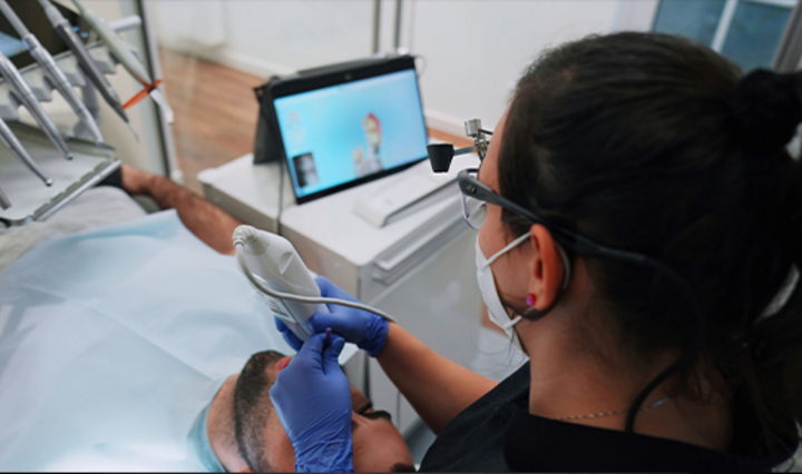 Dentist performing a digital impression and viewing the results on a monitor
