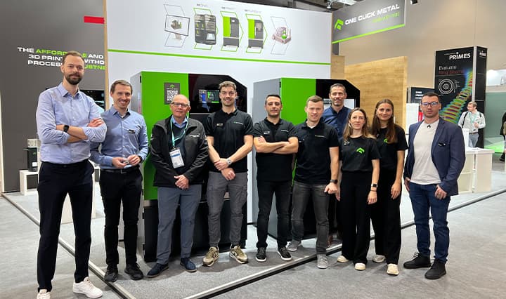 Gruppenbild mit Mitarbeitern von ONE CLICK METAL und imes-icore auf dem Messestand der Formnext