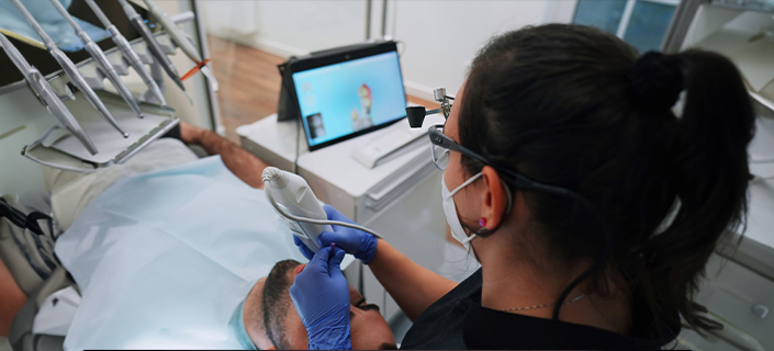 Zahnärztin führt digitale Abformung durch und betrachtet die Ergebnisse auf einem Monitor